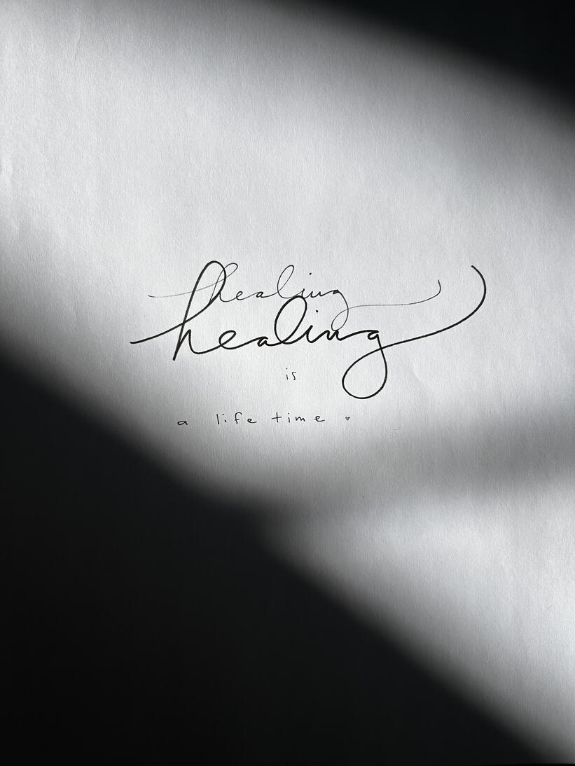 The words "healing is a lifetime" handwritten in shadows.